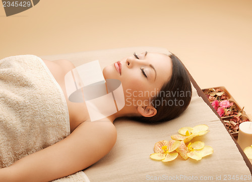 Image of woman in spa salon lying on the massage desk