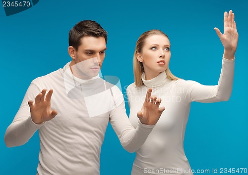 Image of man and woman working with something imaginary