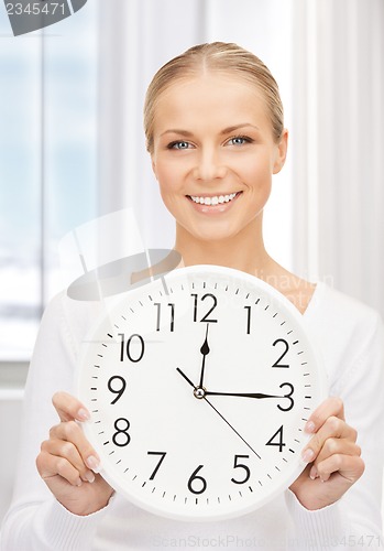 Image of woman holding big clock