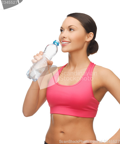 Image of sporty woman drinking water from bottle