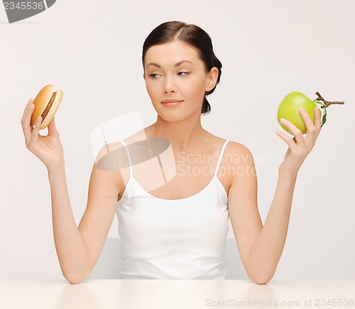 Image of woman with hamburger and apple