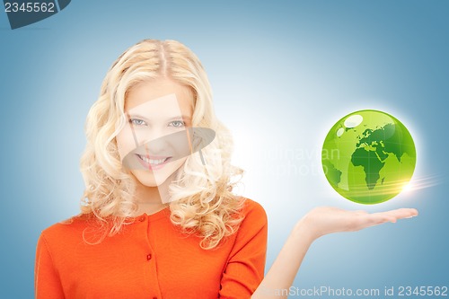 Image of woman holding green globe on her hand