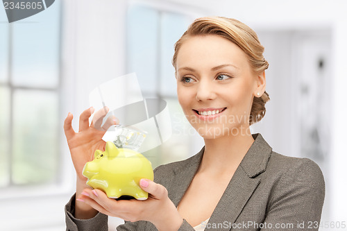 Image of lovely woman with piggy bank and money
