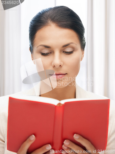 Image of calm and serious woman with book