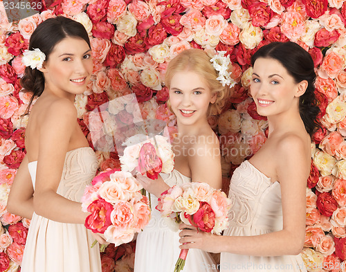 Image of three women with background full of roses