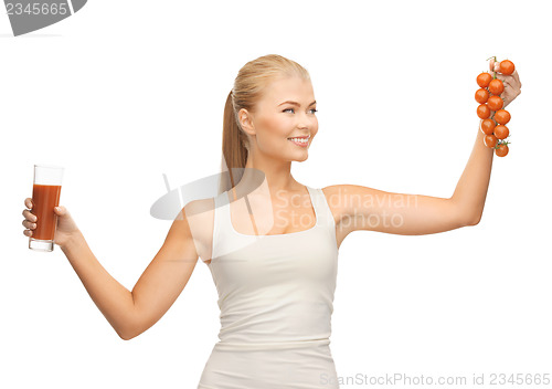 Image of woman holding glass of juice and tomatoes