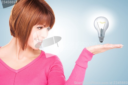 Image of woman showing light bulb on the palm of her hand