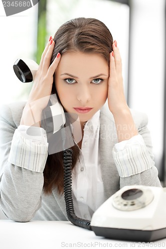 Image of stressed and tired businesswoman with cell phone