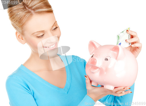 Image of lovely woman with piggy bank and money