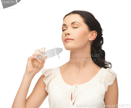 Image of woman spraying perfume on her neck