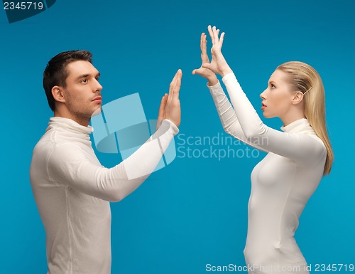 Image of man and woman working with something imaginary