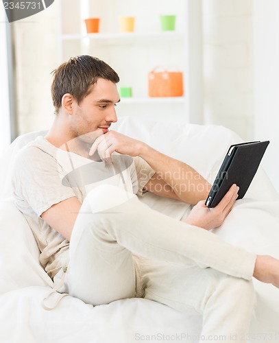 Image of man sitting on the couch with tablet pc