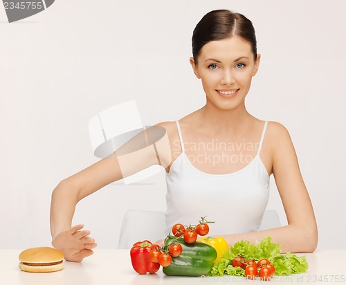 Image of woman with hamburger and vegetables