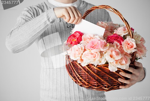 Image of man holding basket full of flowers and postcard