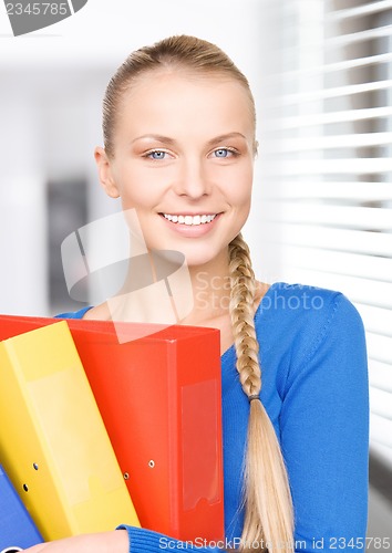 Image of young attractive businesswoman with folders