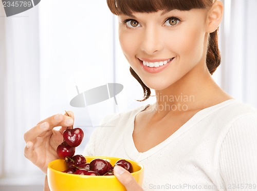 Image of healthy woman holding bowl with cherries