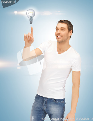 Image of handsome man pointing at light bulb