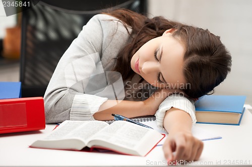 Image of bored and tired woman sleeping on the table