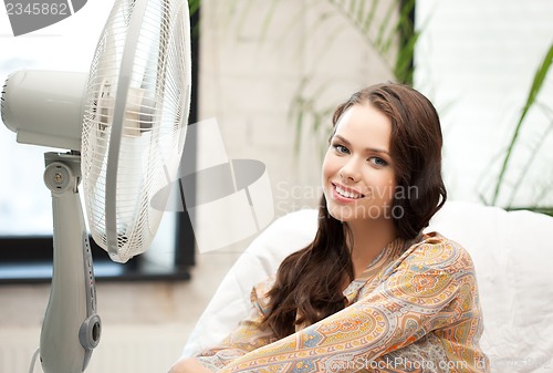 Image of happy and smiling woman sitting near ventilator