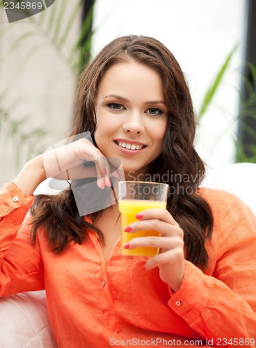 Image of woman holding glass of orange juice