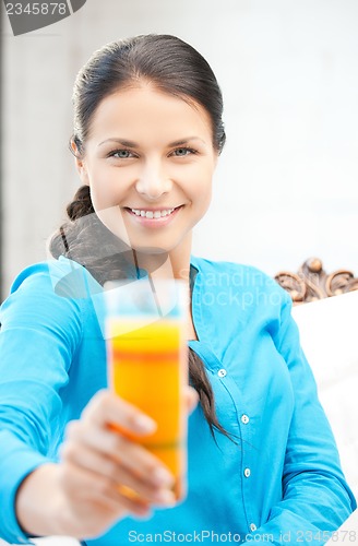 Image of woman holding glass of orange juice