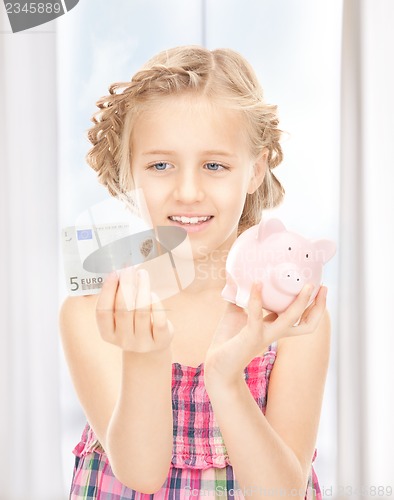 Image of little girl with piggy bank and money