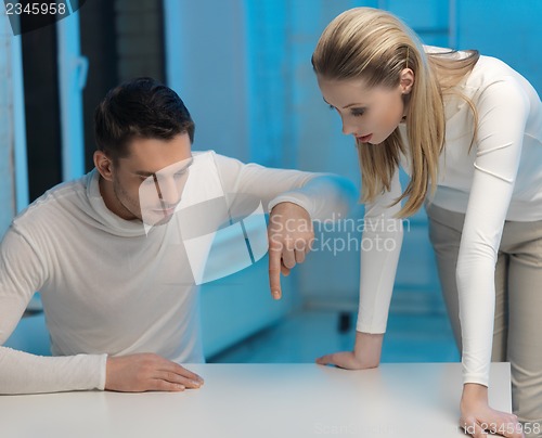 Image of man and woman working with something