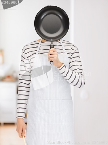 Image of man with pan at kitchen