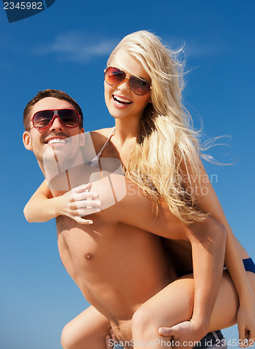 Image of happy couple in sunglasses on the beach