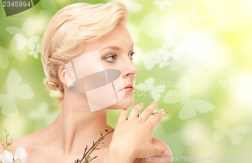 Image of beautiful woman with flowers on twig