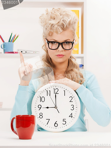 Image of businesswoman with clock and finger up