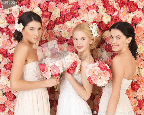Image of three women with background full of roses