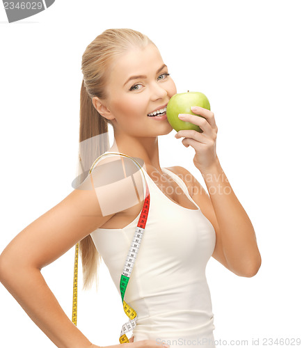 Image of sporty woman with apple and measuring tape