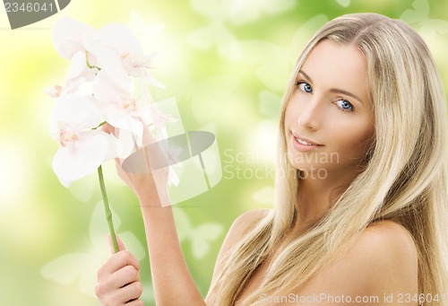 Image of beautiful woman with orchid flower and butterflies