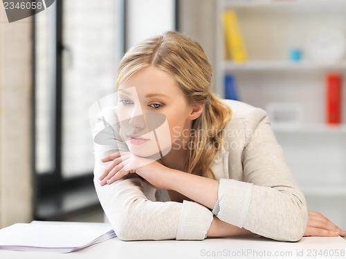 Image of bored and tired woman behind the table