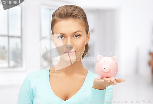 Image of lovely woman with piggy bank