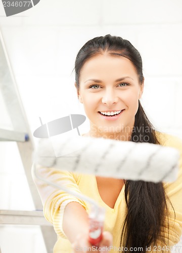 Image of happy young woman with paintroller