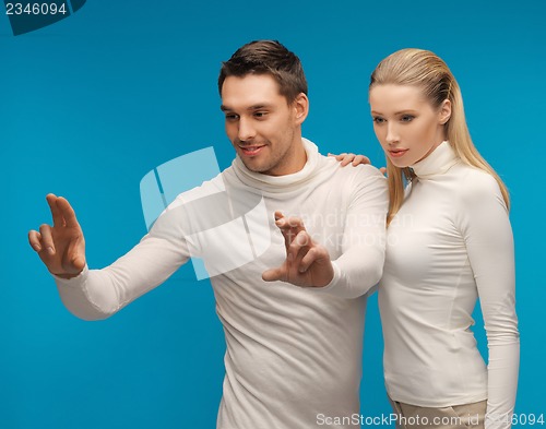 Image of man and woman working with something imaginary