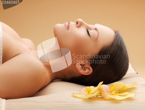 Image of woman in spa salon lying on the massage desk