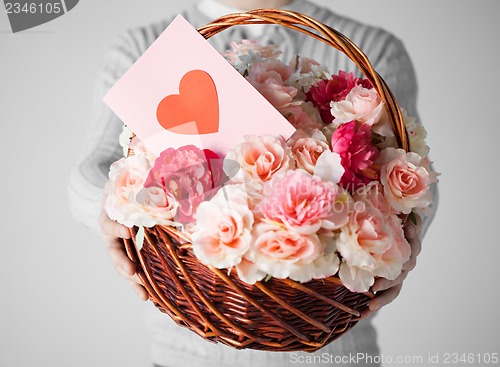Image of man holding basket full of flowers and postcard