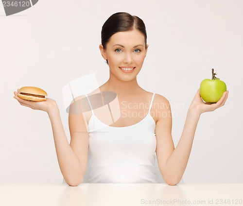 Image of woman with hamburger and apple