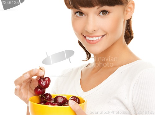 Image of healthy woman holding bowl with cherries