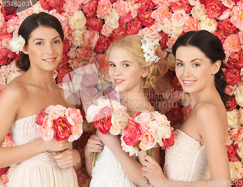 Image of three women with background full of roses