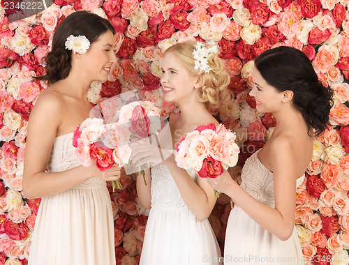 Image of three women with background full of roses