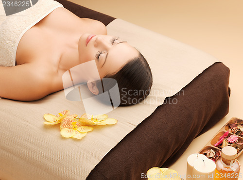 Image of woman in spa salon lying on the massage desk