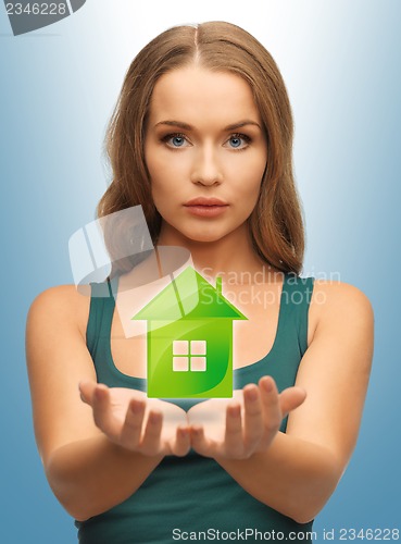 Image of woman holding green house in her hands