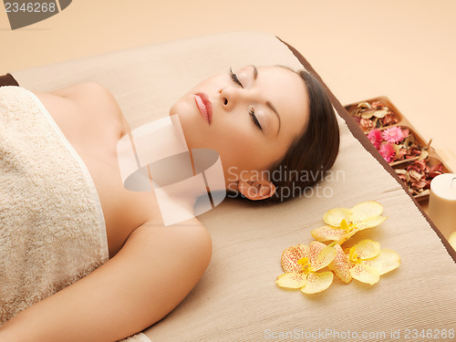 Image of woman in spa salon lying on the massage desk