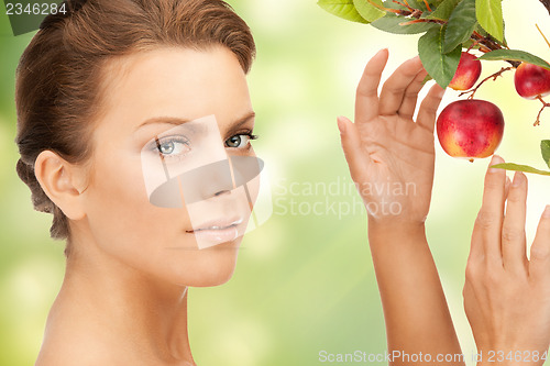 Image of lovely woman with apple twig