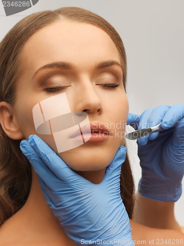 Image of woman face and beautician hands