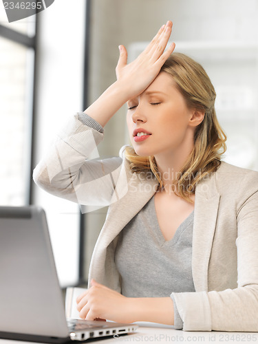 Image of businesswoman holding her head with hand